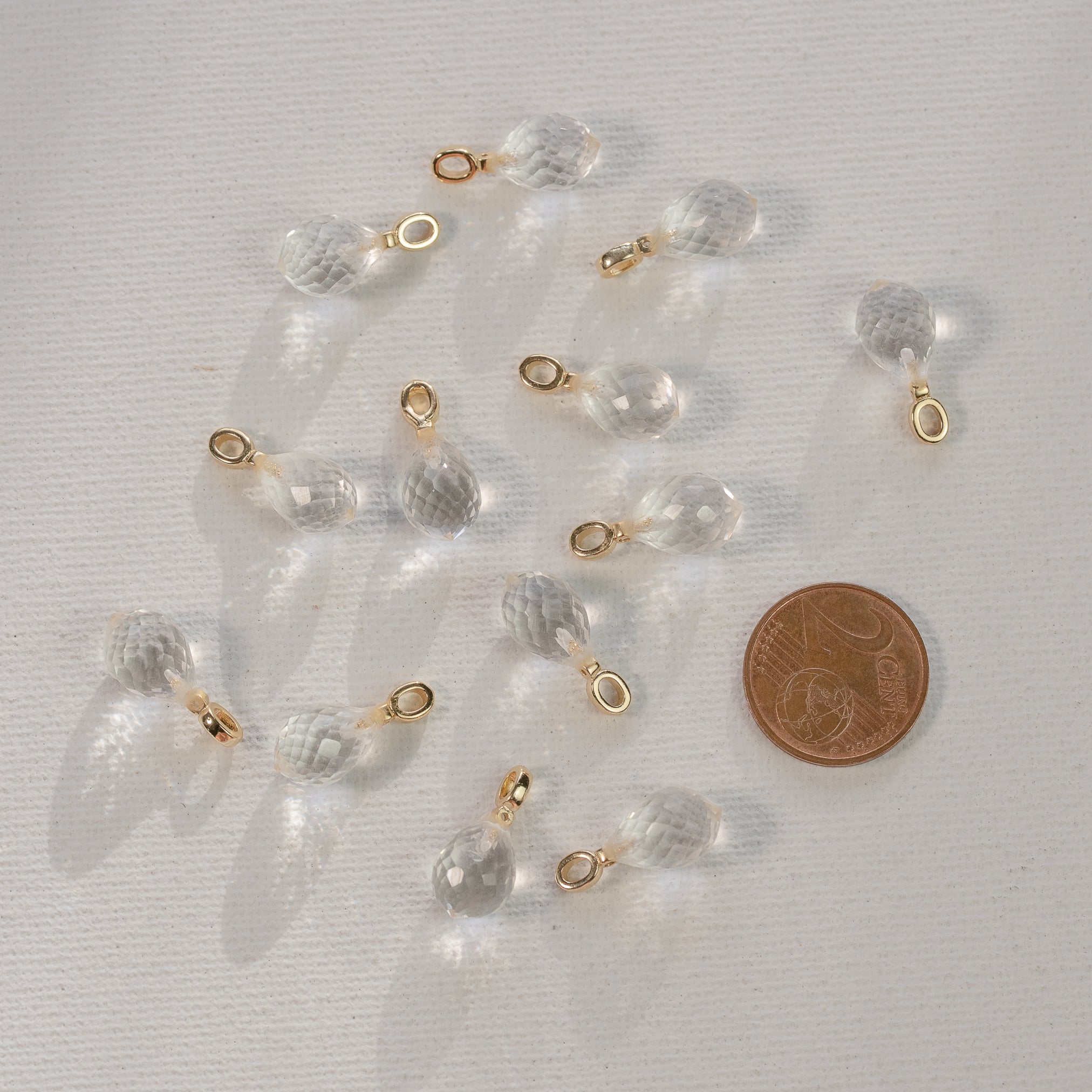 Les petits charms gouttes facettes " Nidhih " en Cristal de roche, laiton plaqué or et zirconium de 17 mm ( à l&