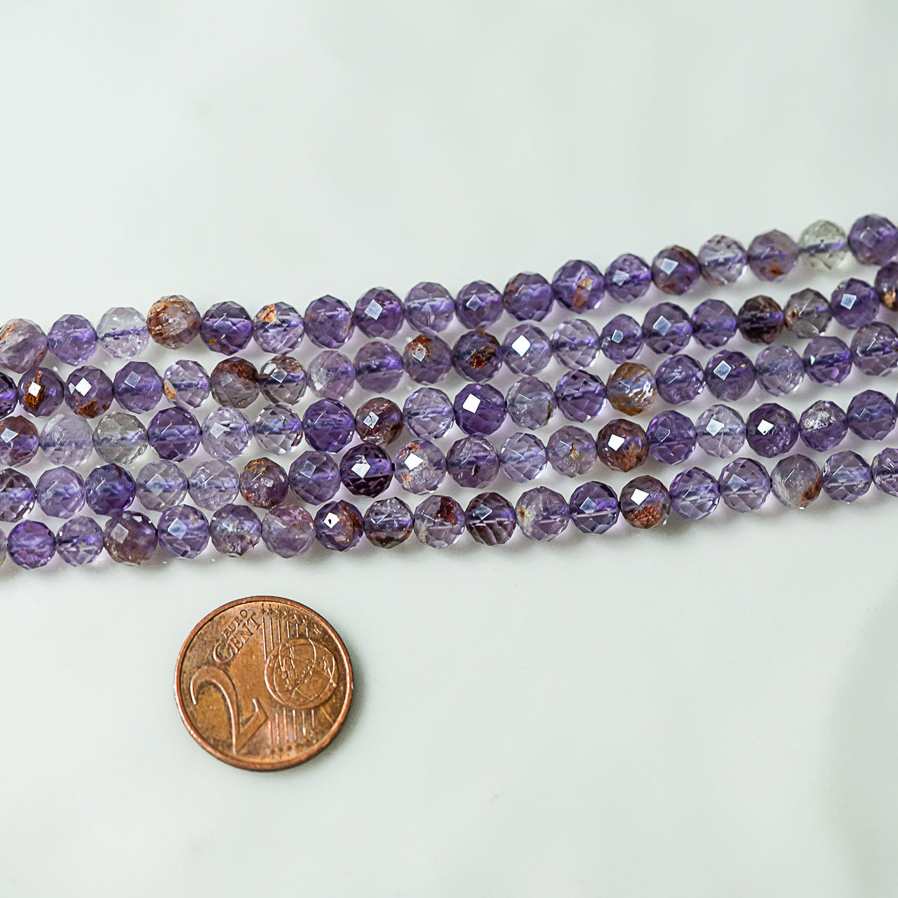 Perles rondes facettes en Améthyste à inclusions de 5 mm ( 1/2 rang de env 36 perles )
