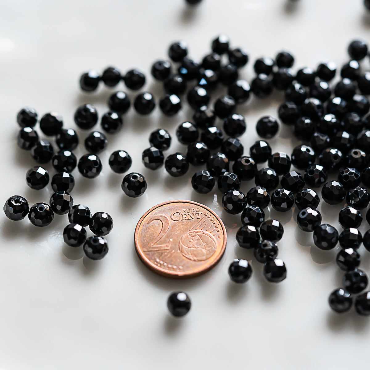 Perles rondes facettes de Spinelle noire de 5 ou 5,5 mm ( 1/2 rang de env 42/35 perles )