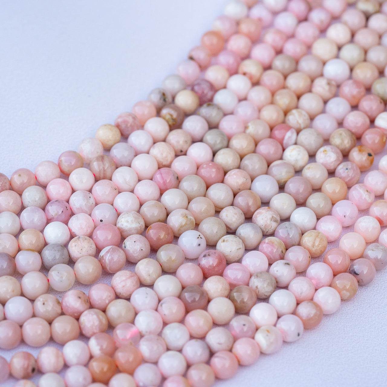 Perles rondes lisses en Opale rose grade a de 6/6,5 mm ( 1/2 rang de env 34/30 perles )