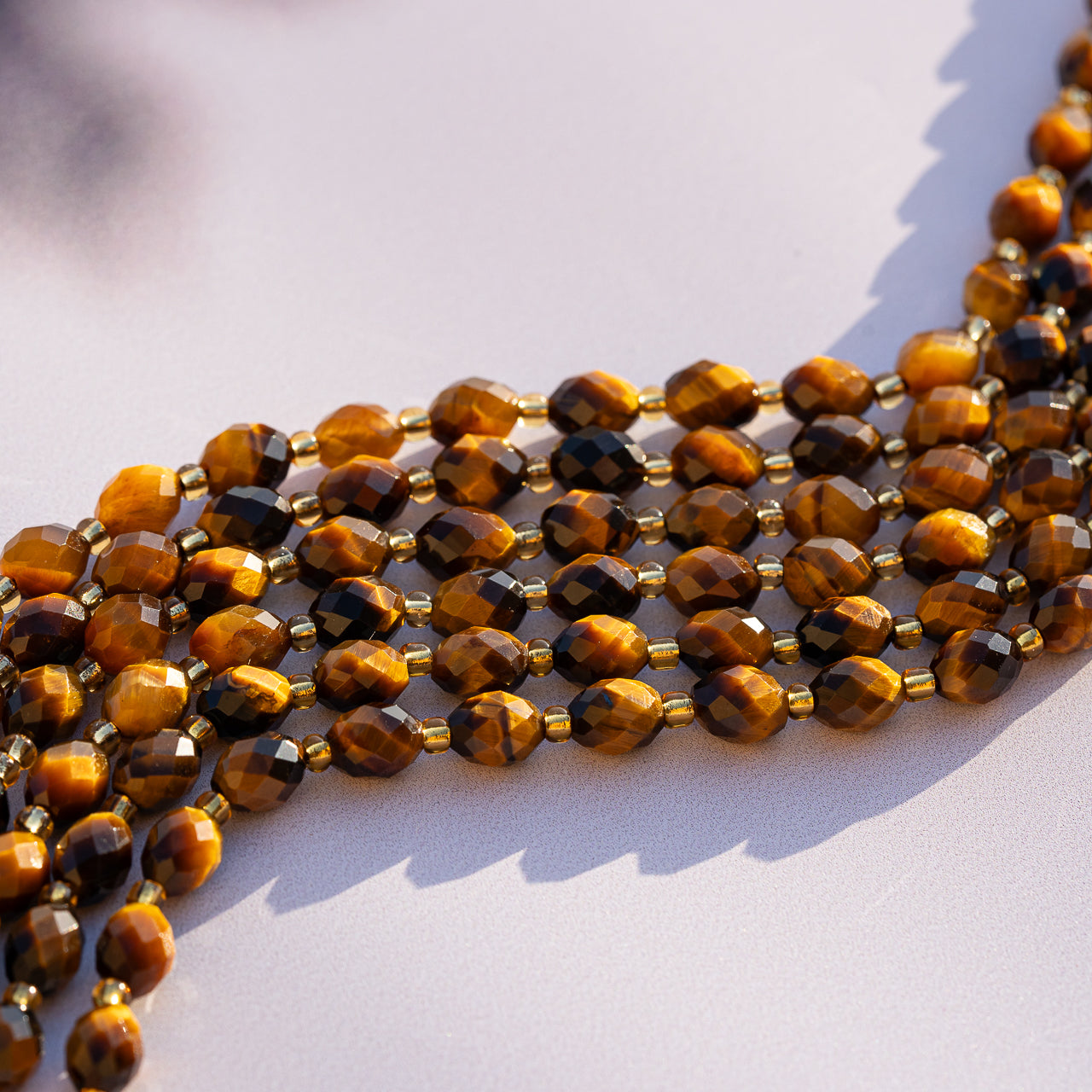 Perles ovales facettes en Oeil de tigre de 8 mm ( 1/2 rang de env 19 perles )