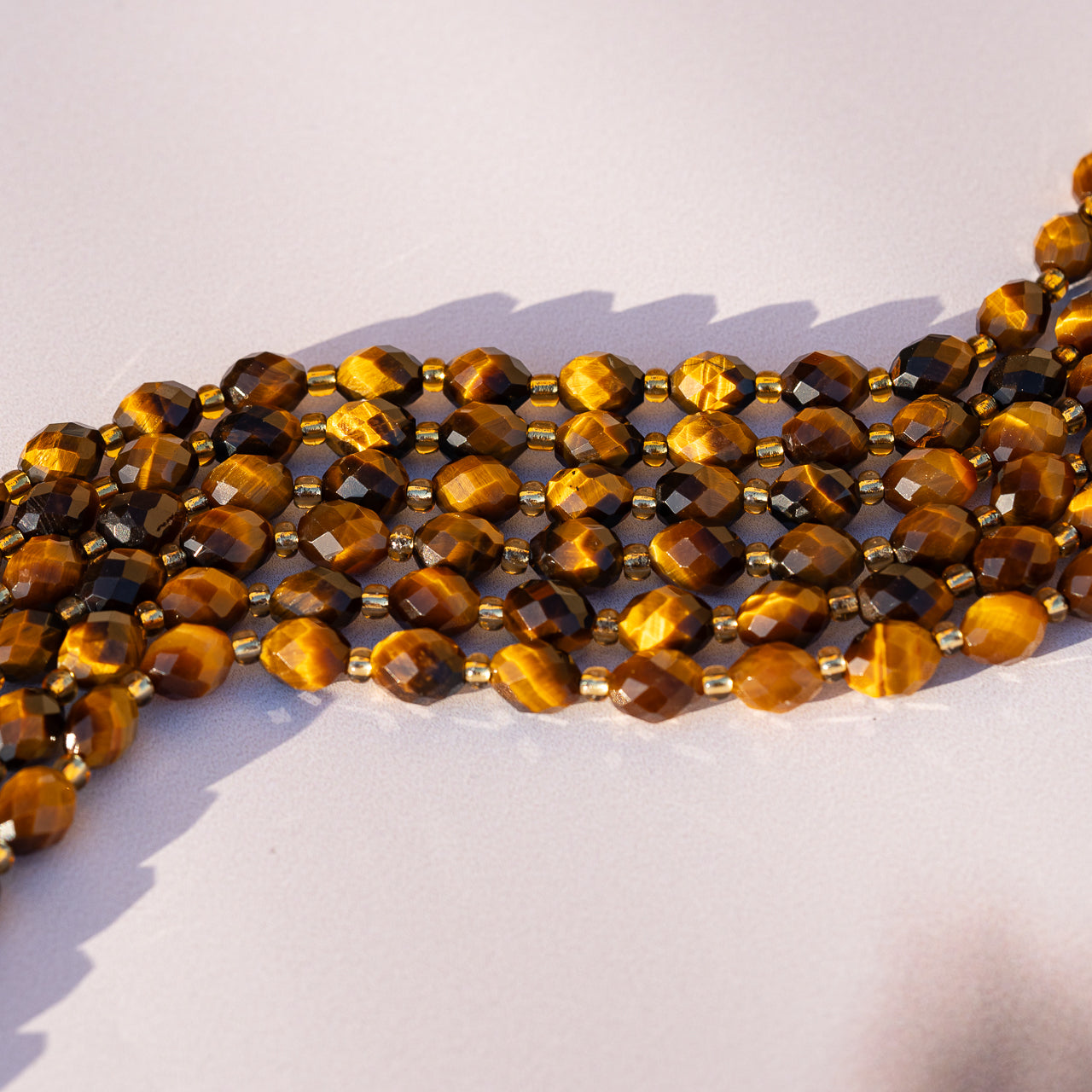 Perles ovales facettes en Oeil de tigre de 8 mm ( 1/2 rang de env 19 perles )