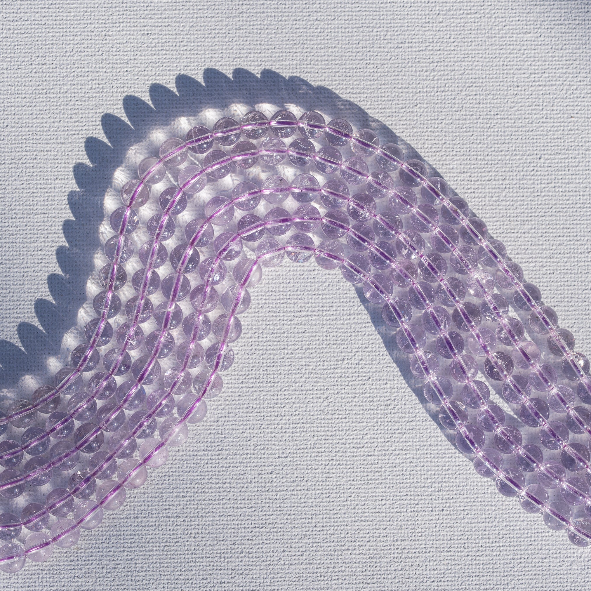 Perles rondes lisses en Améthyste lilas grade A de 6,5 mm ( 1/2 rang de env 30 perles )