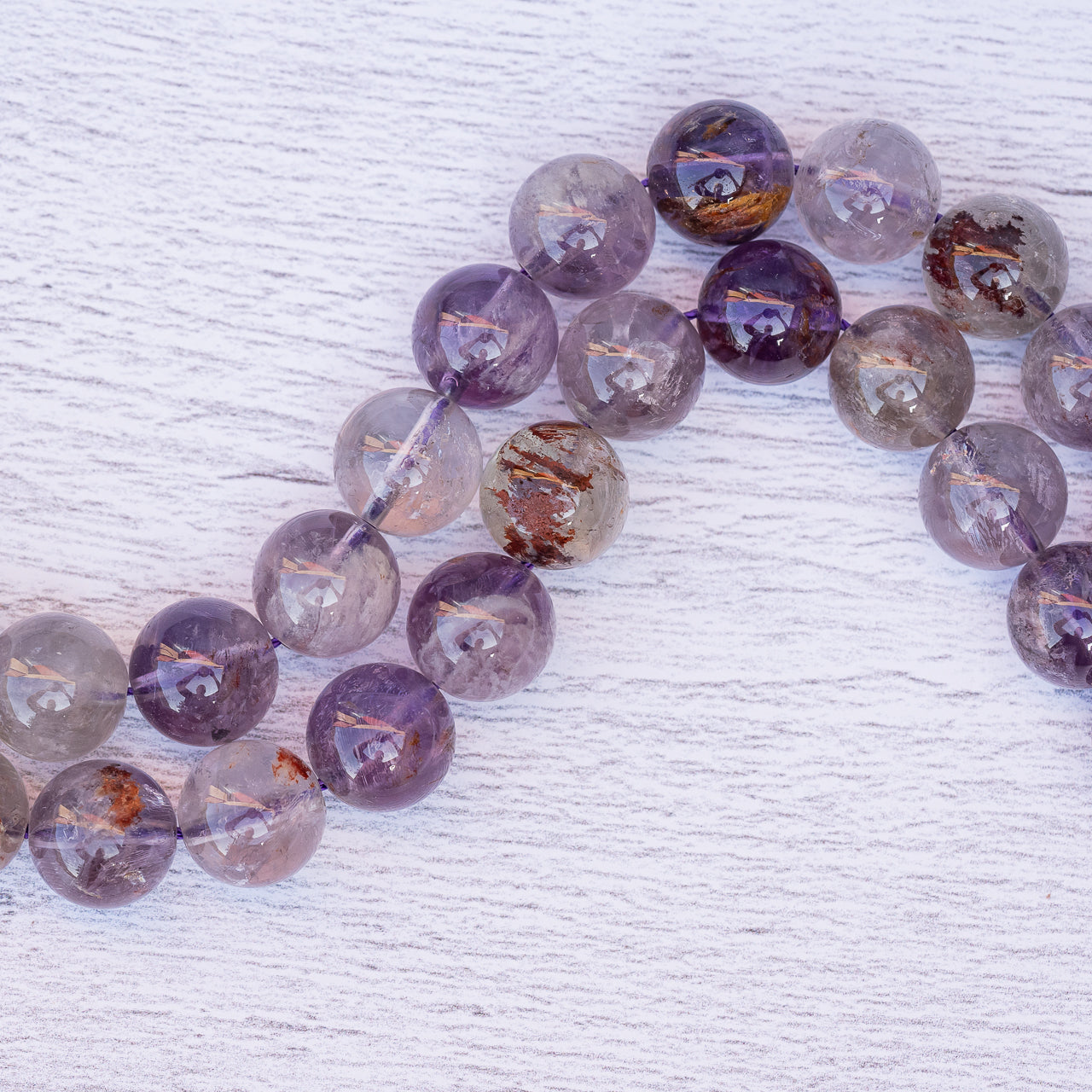 Perles rondes lisses en Améthyste à inclusions de 12 mm ( 1/2 rang de env 17 perles )