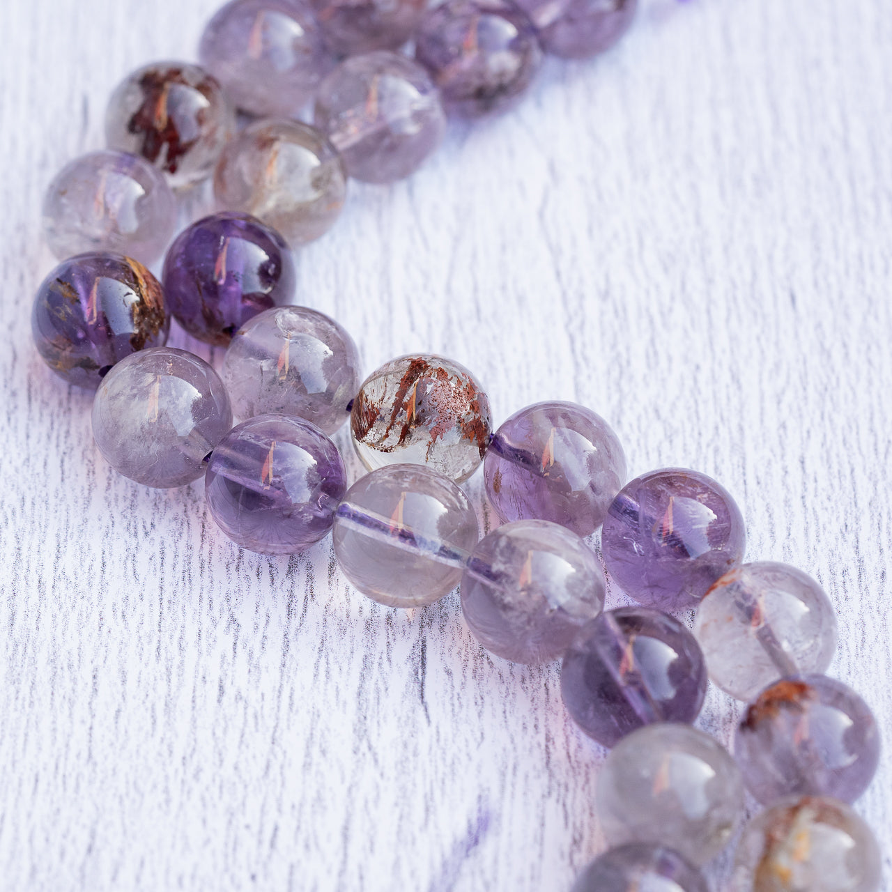 Perles rondes lisses en Améthyste à inclusions de 12 mm ( 1/2 rang de env 17 perles )