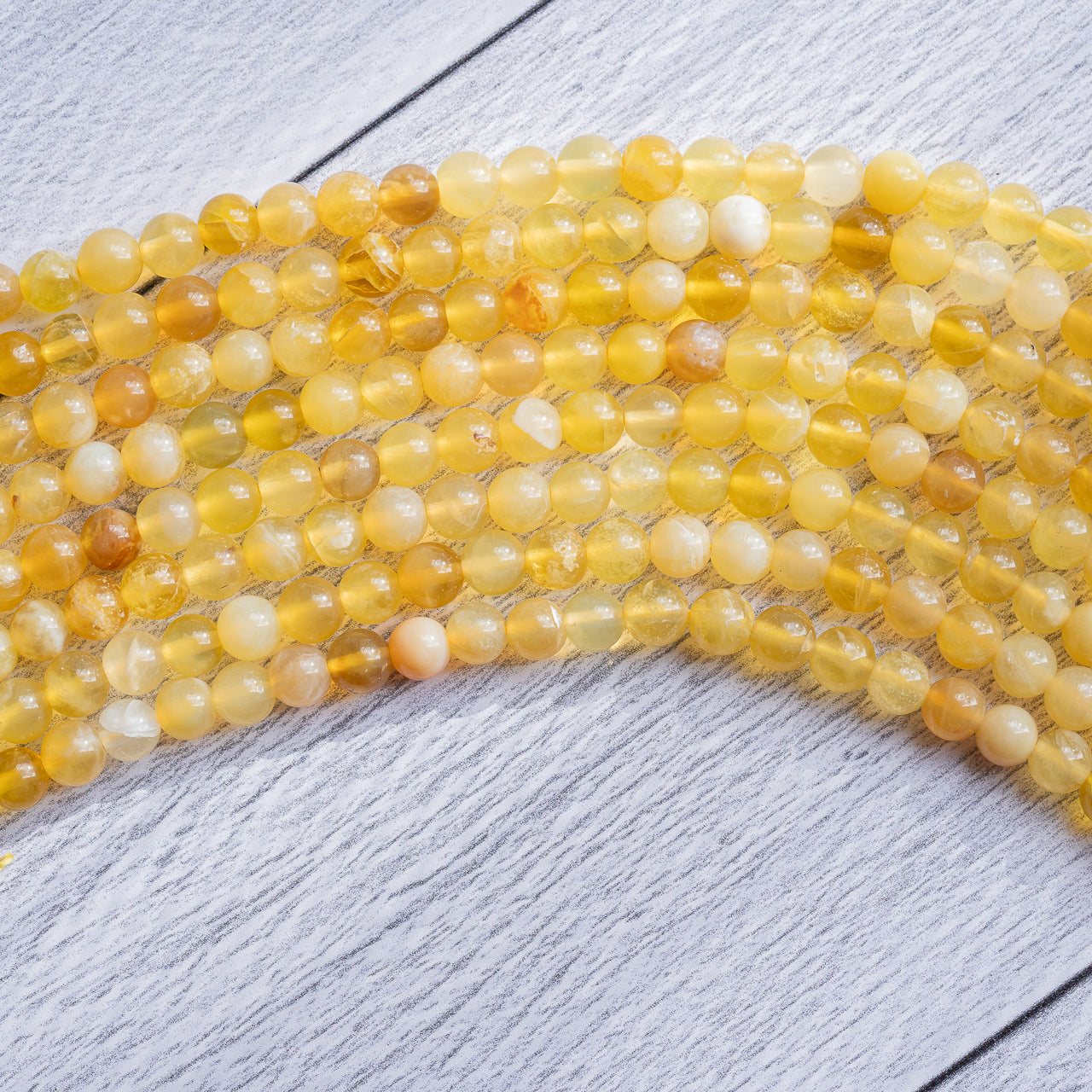 Perles rondes lisses en Opale jaune grade a de 5,5 mm ( 1/2 rang de env 34 perles )
