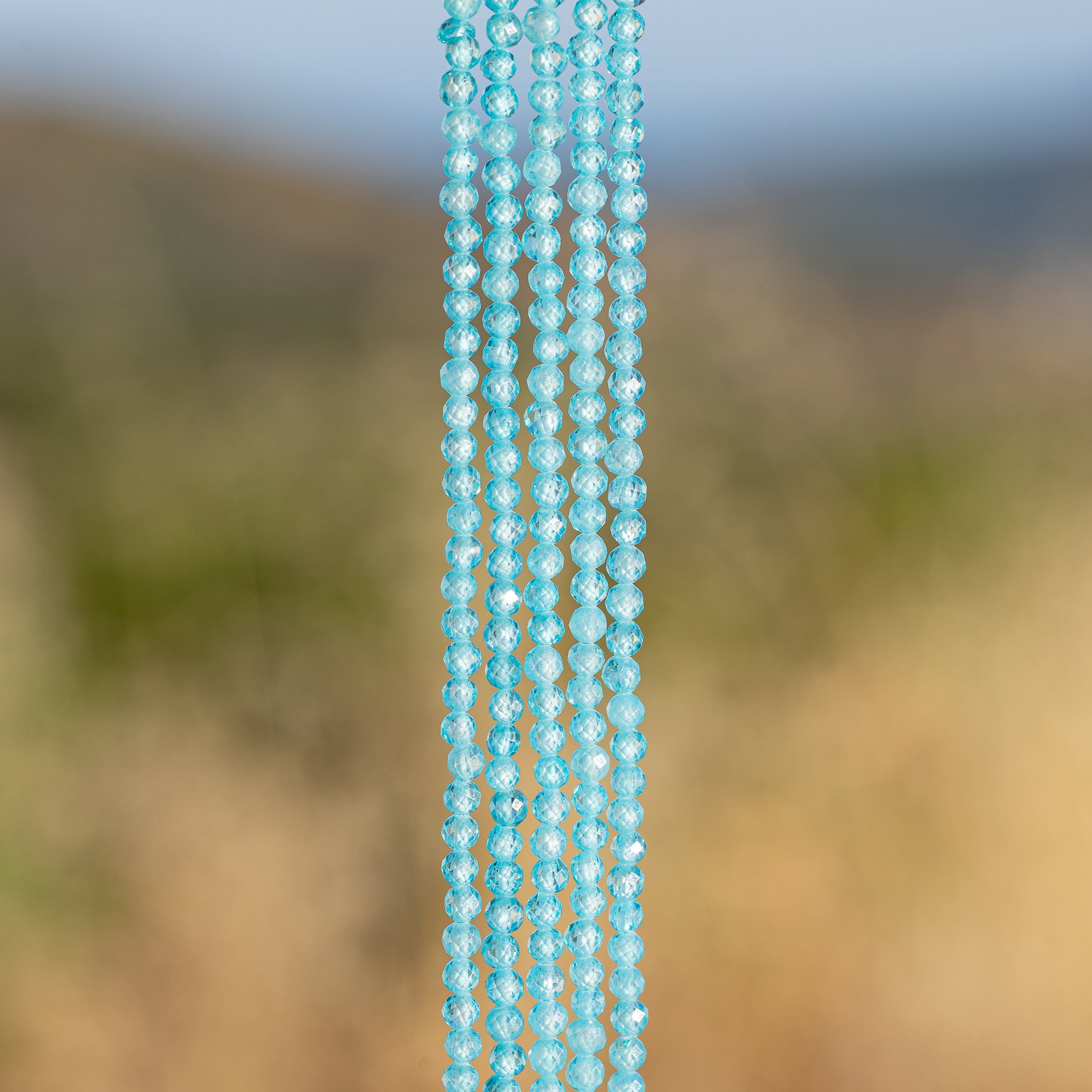Perles rondes facettes de zirconium bleu topaze de 3 mm ( 1/2 rang de env 63 perles )