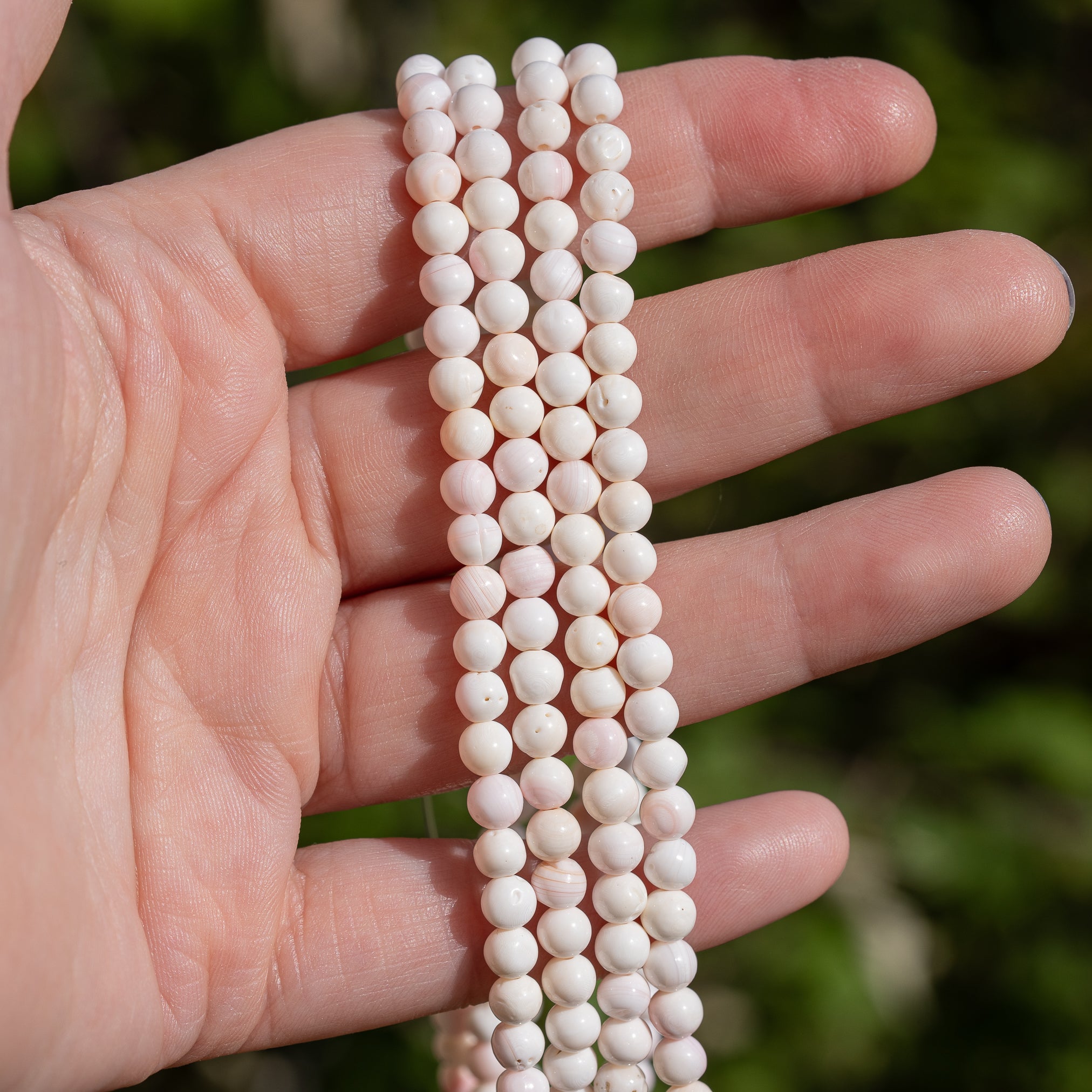 Perles rondes lisses de nacre rosée de 5 mm ( rang de env 40 cm et 82 perles )