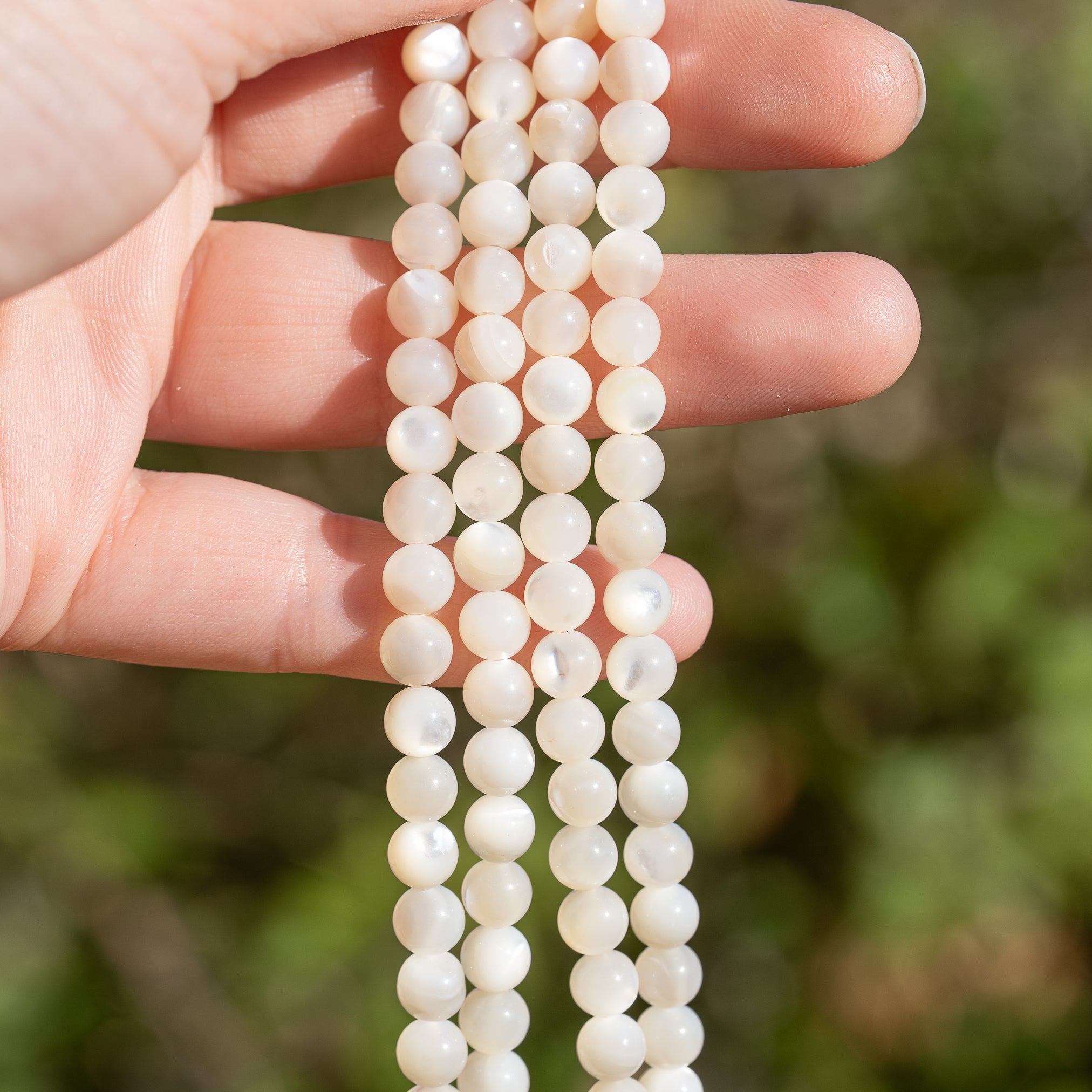 Perles rondes lisses de nacre blanche de 6 mm ( rang de env 62 perles )