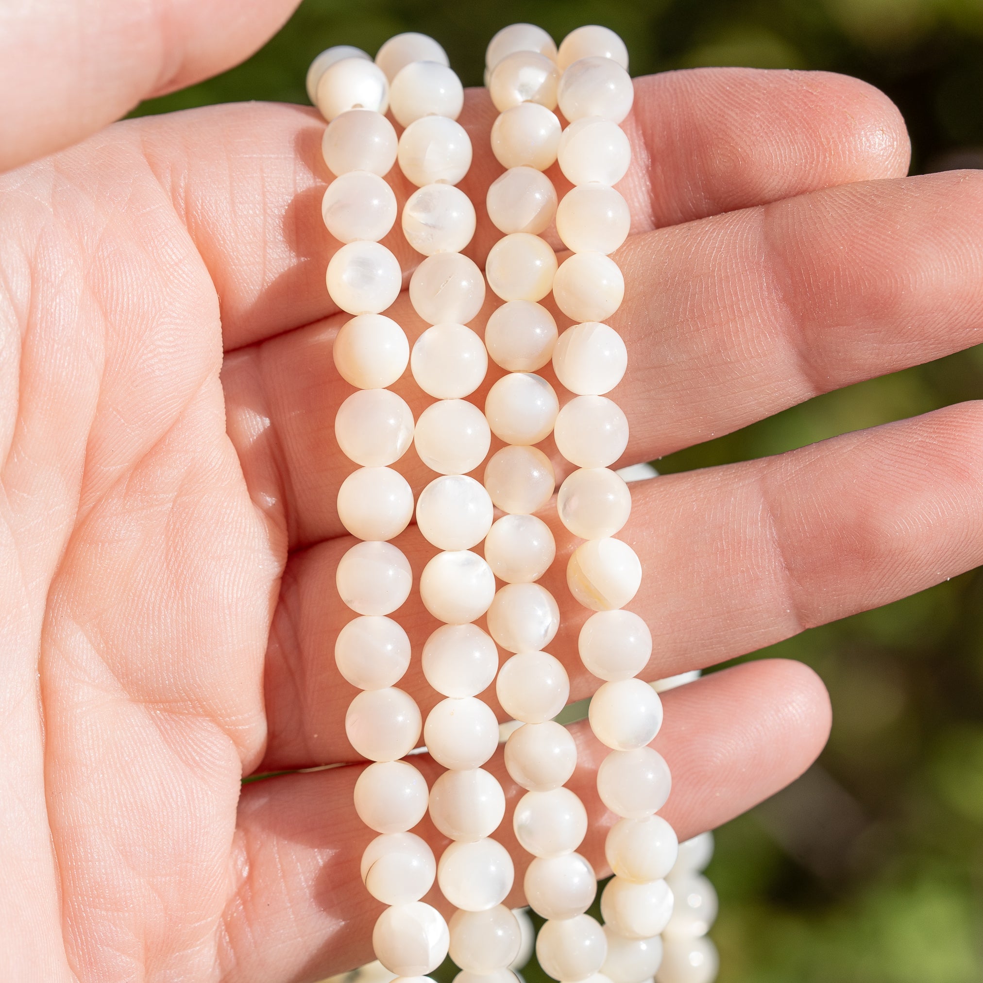 Perles rondes lisses de nacre blanche de 6 mm ( rang de env 62 perles )