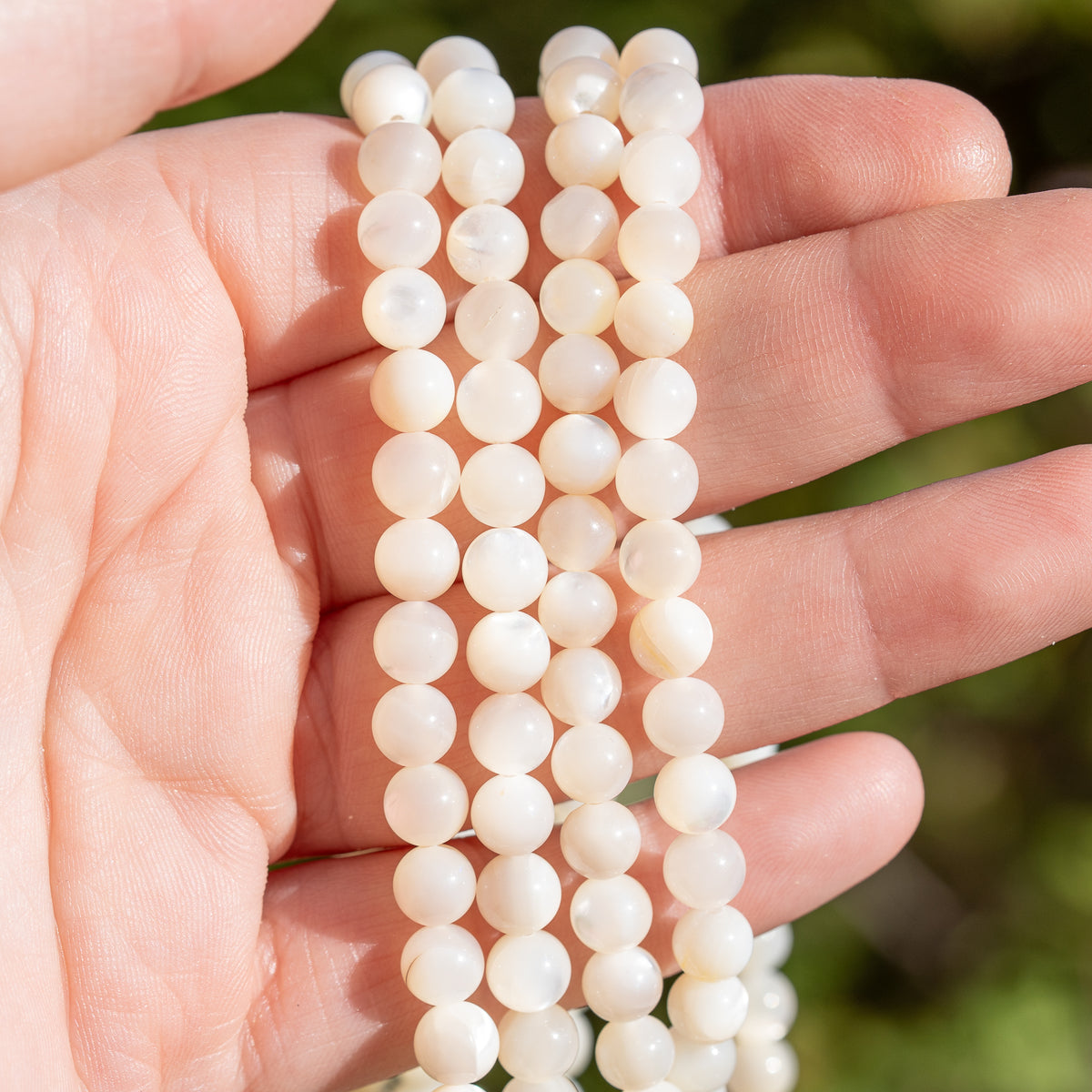 Perles rondes lisses de nacre blanche de 6 mm ( rang de env 62 perles )