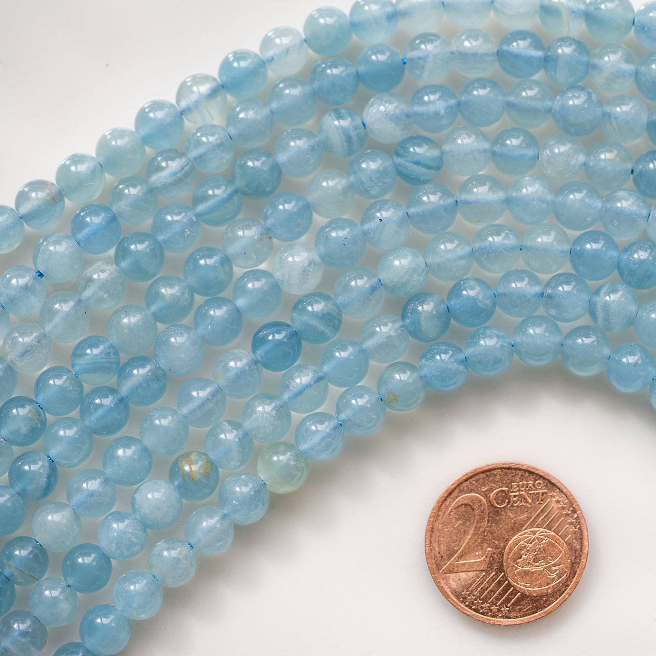 Perles rondes lisses de calcite bleue de 5,5 mm ( 1/2 rang de env 35 perles )