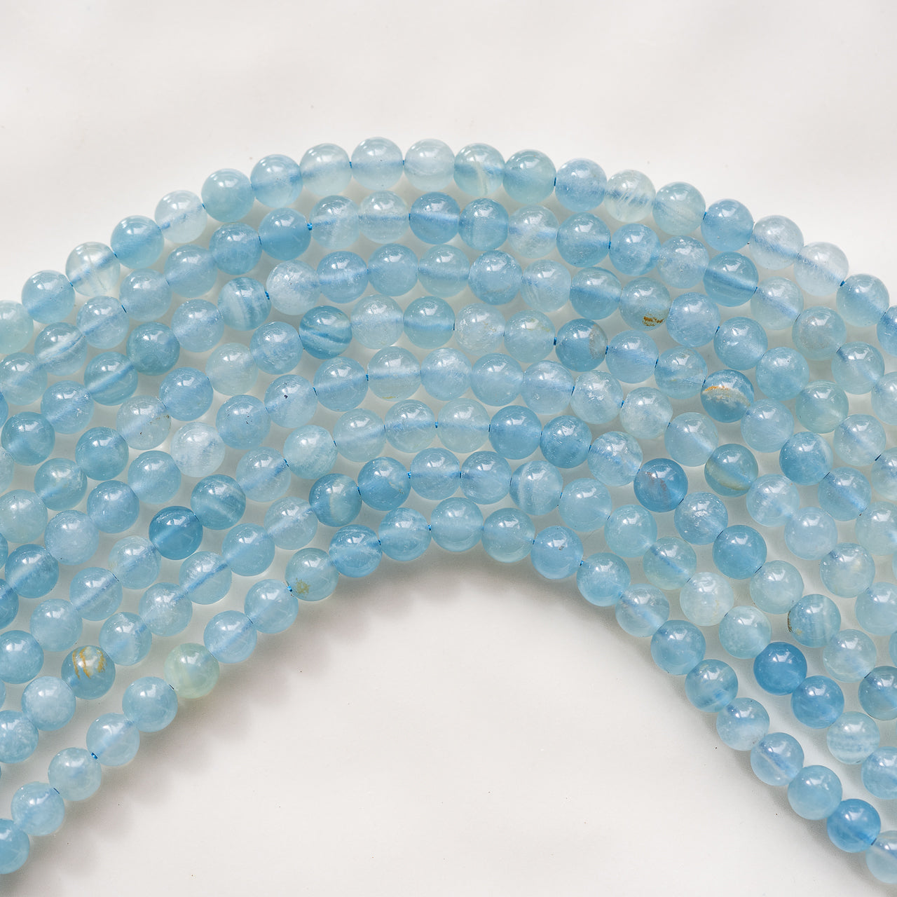 Perles rondes lisses de calcite bleue de 5,5 mm ( 1/2 rang de env 35 perles )