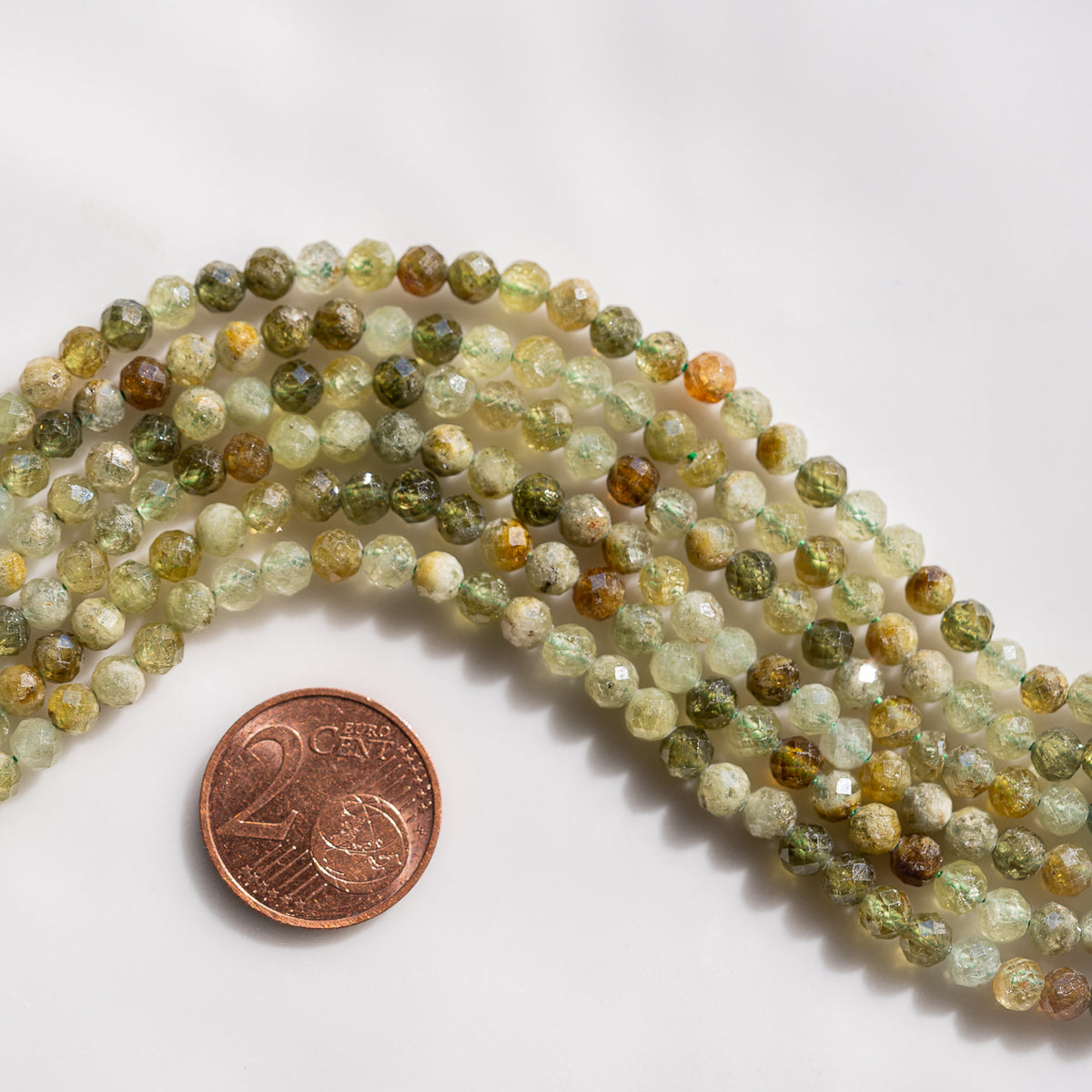 Perles rondes facettes de Grenat brun/vert andradite de 4,3 mm ( 1/2 rang de env 46 perles )