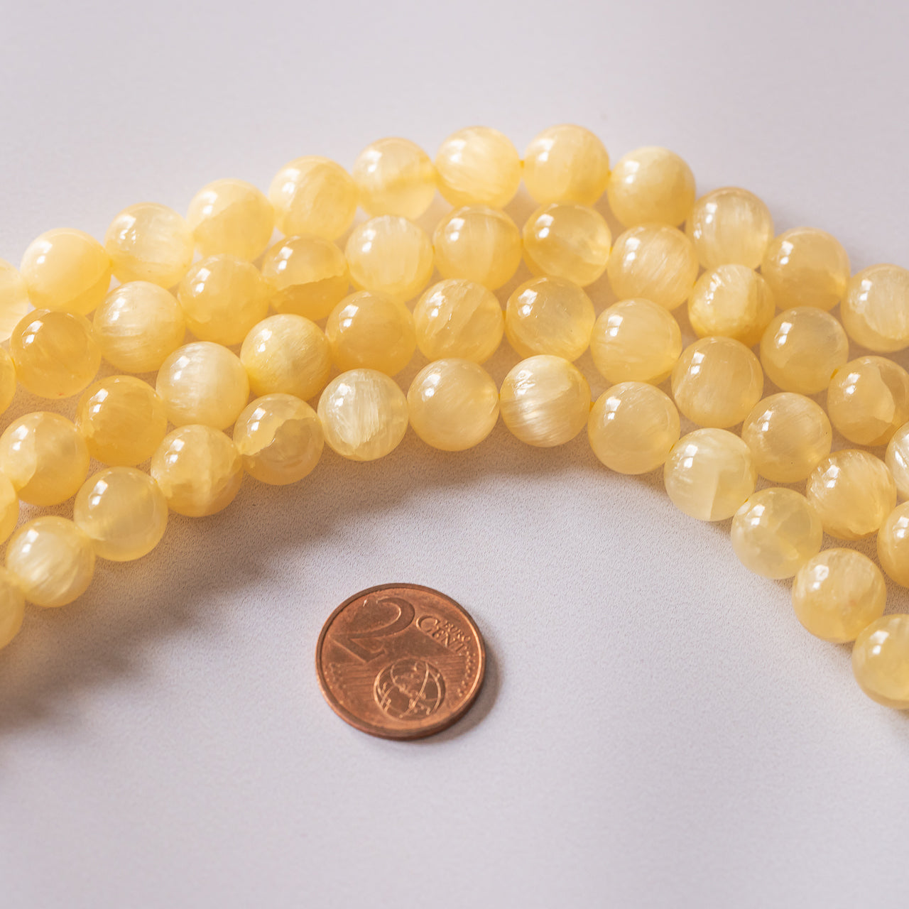 Perles rondes lisses de Calcite miel de 10 mm ( 1/2 rang de env 20 perles )