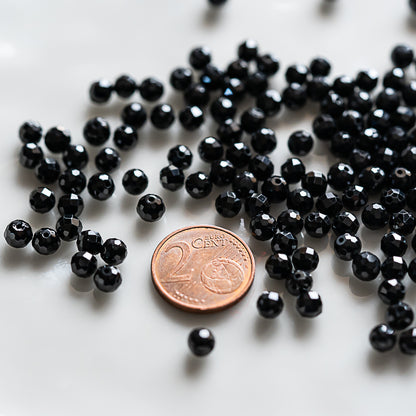 Perles rondes facettes de Spinelle noire de 5 ou 5,5 mm ( 1/2 rang de env 42/35 perles )