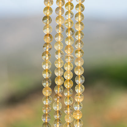 Perles rondes lisses de Fluorite jaune de 6,3 mm ( 1/2 rang de env 32 perles )