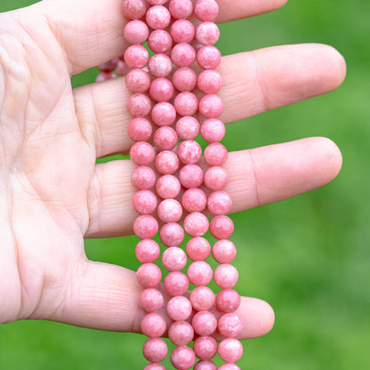 Perles rondes lisses de Thulite de 6 mm ( 1/2 rang de env 31/32 perles )