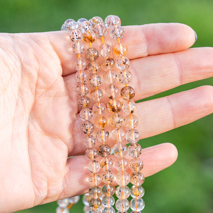 Perles rondes lisses de Quartz à inclusions de 6/7 mm ( par 1/2 rang )