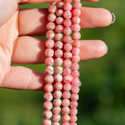 Perles rondes lisses de Rhodochrosite de 6/7 mm ( par 1/2 rang )