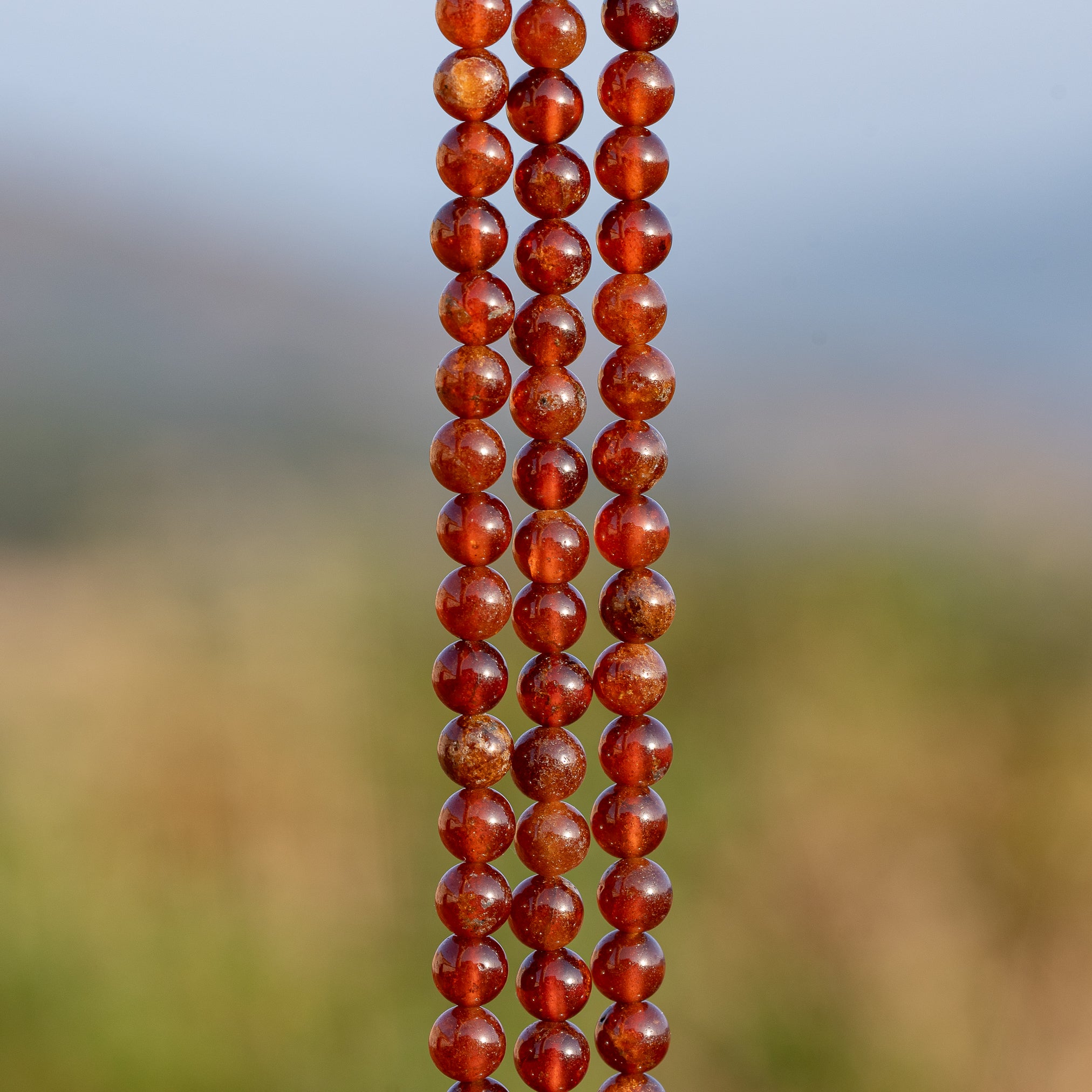 Perles rondes lisses de Grenat orange de 5,8 mm ( 1/2 rang de env 34 perles )