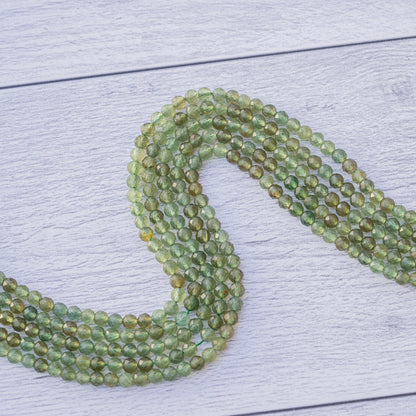 Perles rondes facettes en Apatite verte de 4 mm ( rang de env 98 perles )