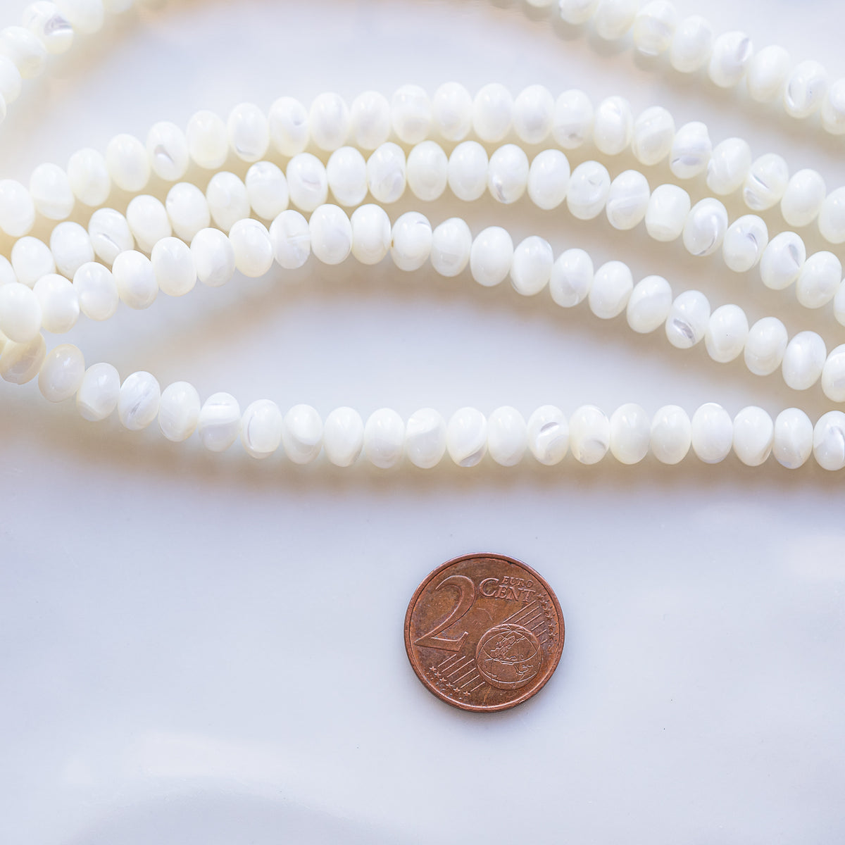 Perles rondelles lisses de nacre de 7 x 5 mm ( rang de env 78 perles )