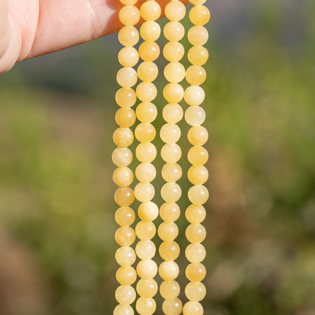 Perles rondes lisses de jade jaune de 6 mm ( rang de env 62 perles )
