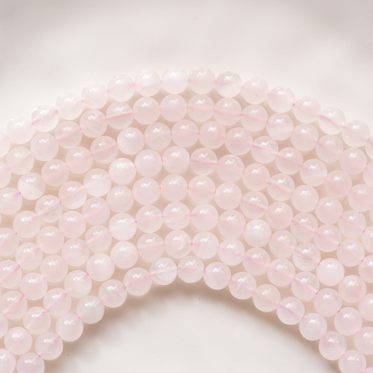 Perles rondes lisses de calcite rose de 8 mm ( 1/2 rang de env 24 perles )