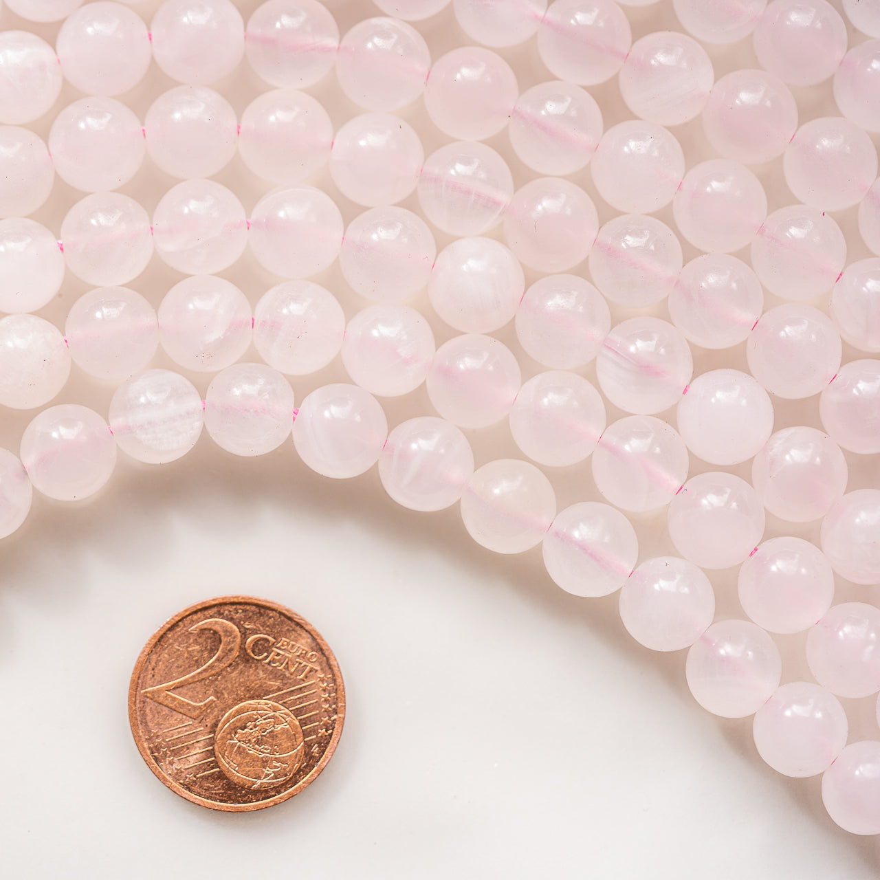 Perles rondes lisses de calcite rose de 8 mm ( 1/2 rang de env 24 perles )