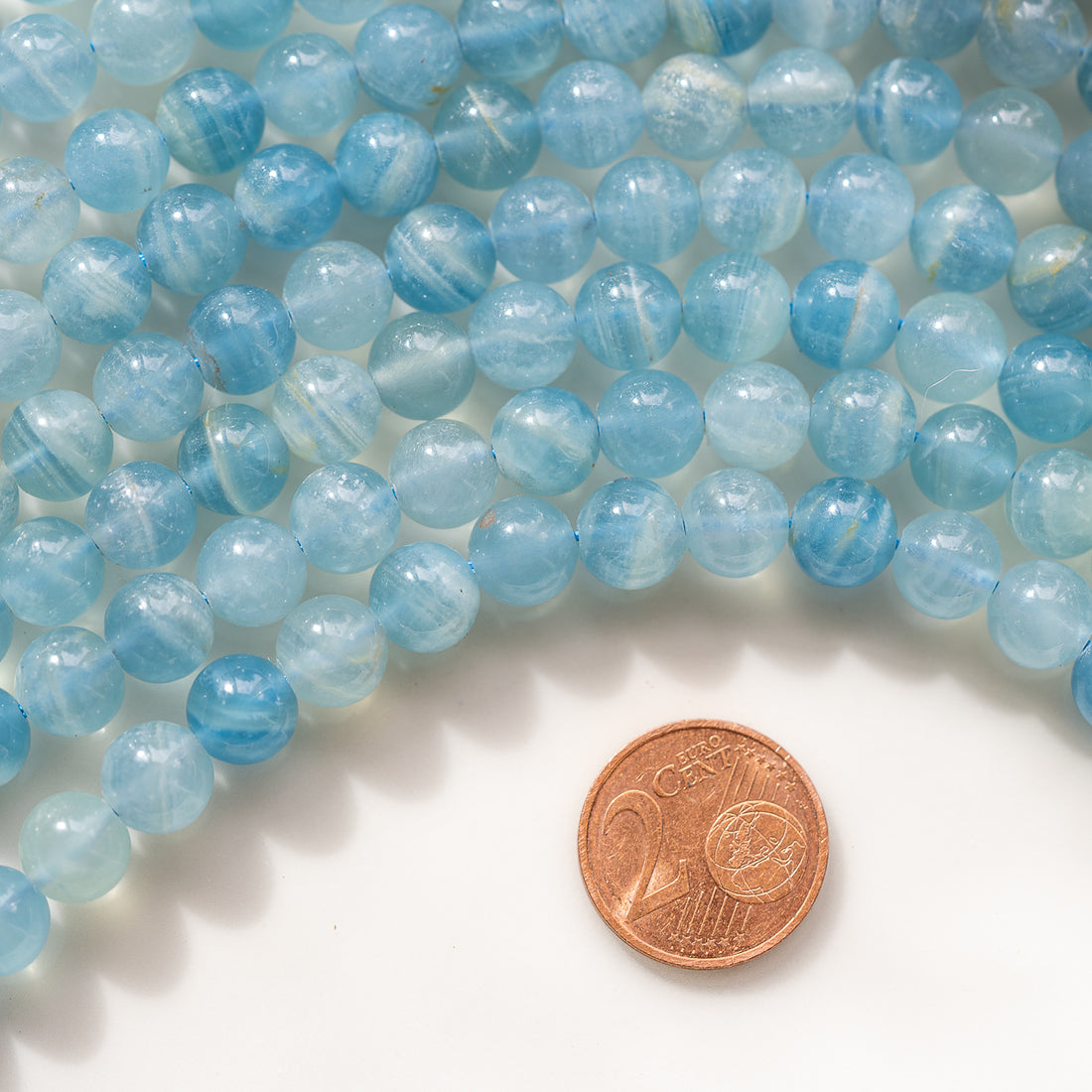 Perles rondes lisses de calcite bleue de 8 mm ( 1/2 rang de env 24 perles )