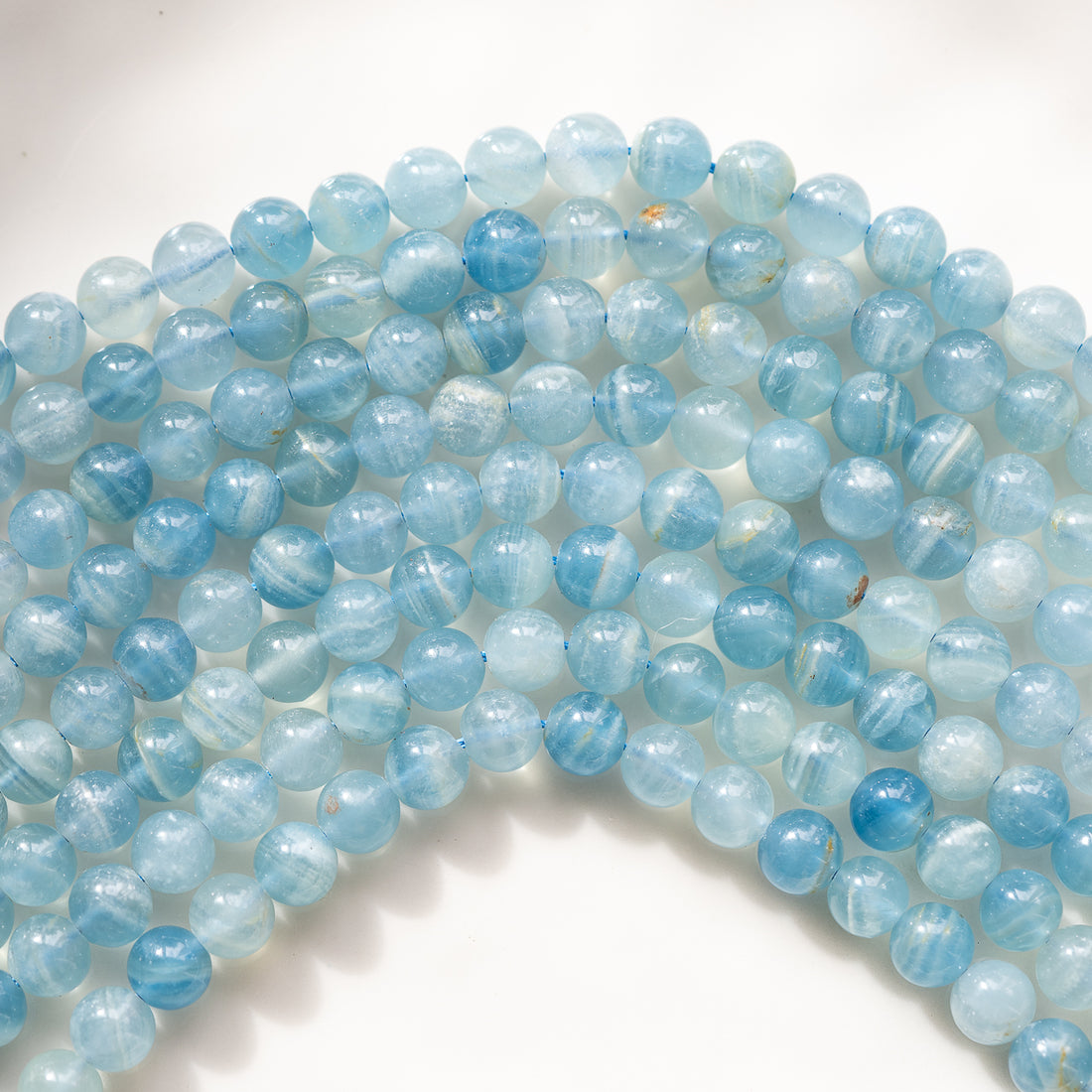 Perles rondes lisses de calcite bleue de 8 mm ( 1/2 rang de env 24 perles )