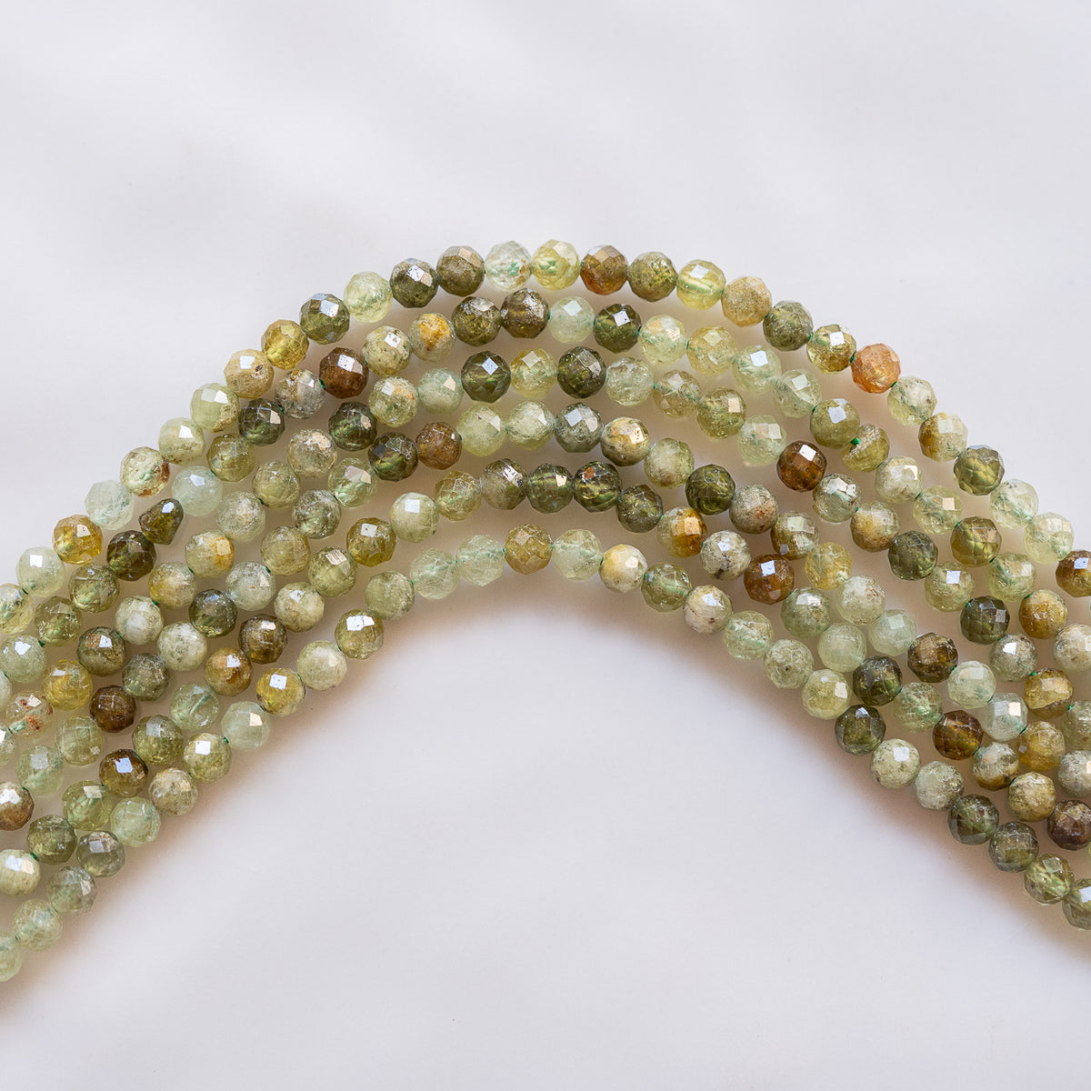 Perles rondes facettes de Grenat brun/vert andradite de 4,3 mm ( 1/2 rang de env 46 perles )