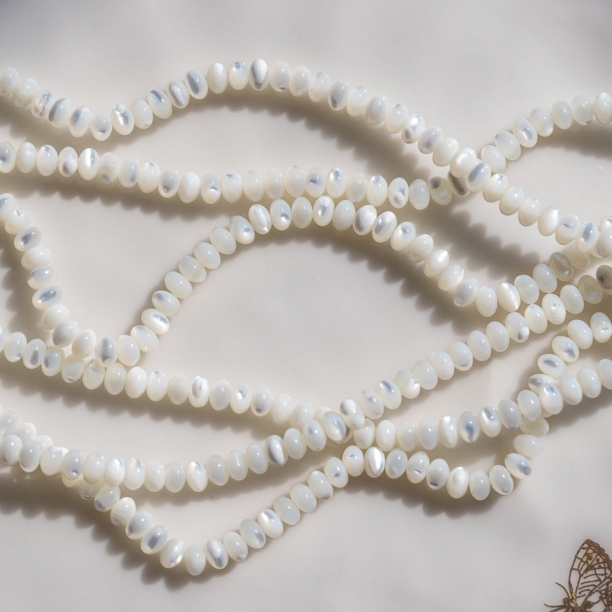 Perles rondelles lisses de nacre blanche de 6 x 3,5 mm ( rang de env 102 perles )