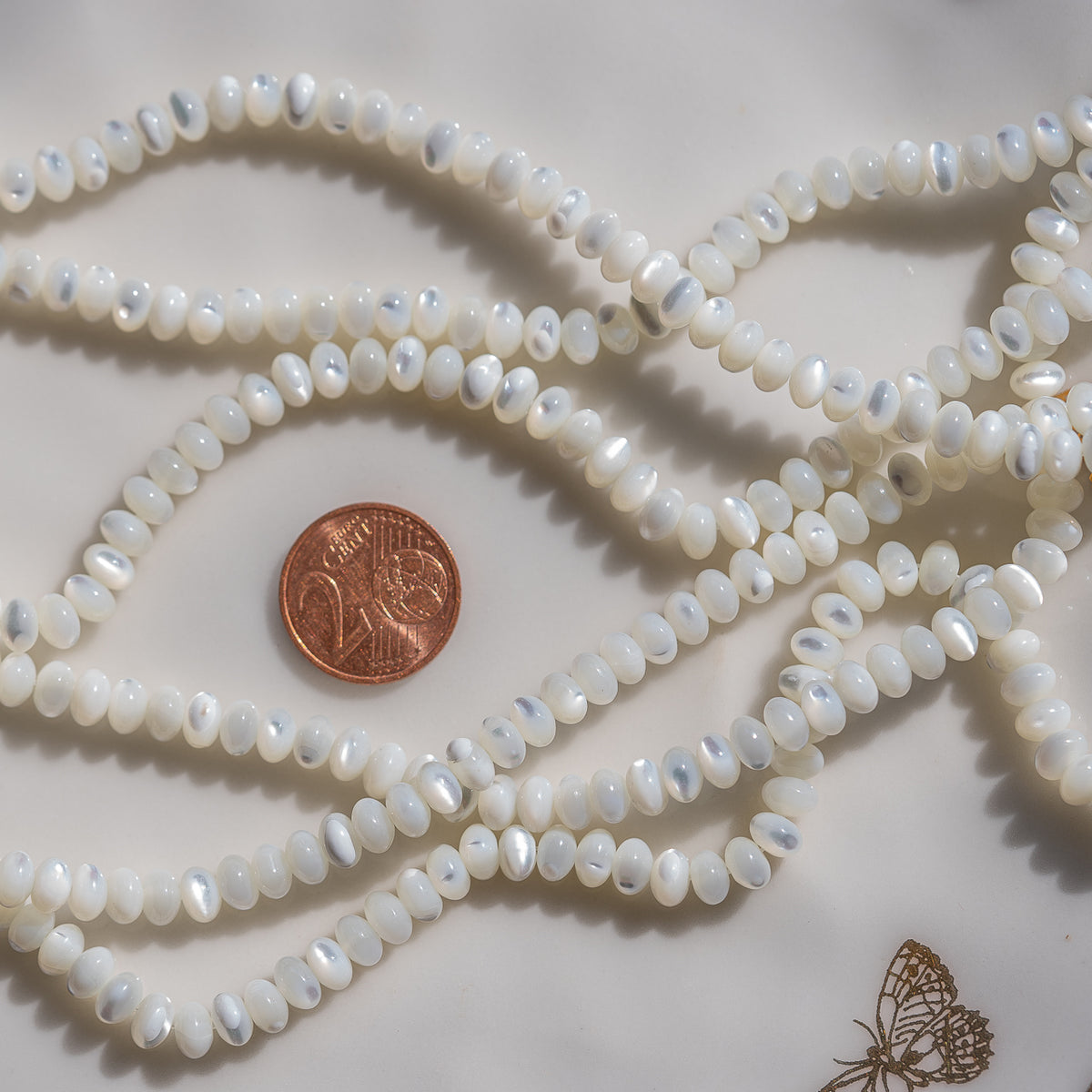 Perles rondelles lisses de nacre blanche de 6 x 3,5 mm ( rang de env 102 perles )