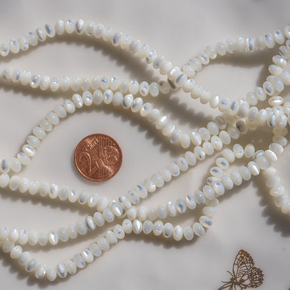Perles rondelles lisses de nacre blanche de 6 x 3,5 mm ( rang de env 102 perles )